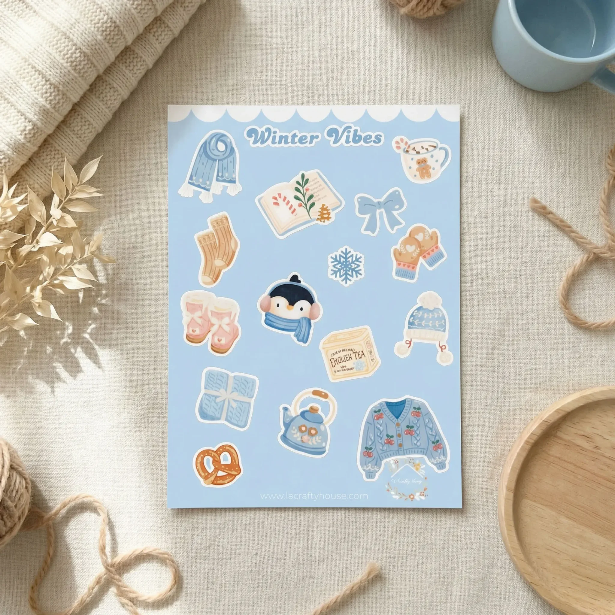 Planche de stickers Winter Vibes posée sur une nappe de lin à côté d'une tasse bleue by La Crafty House