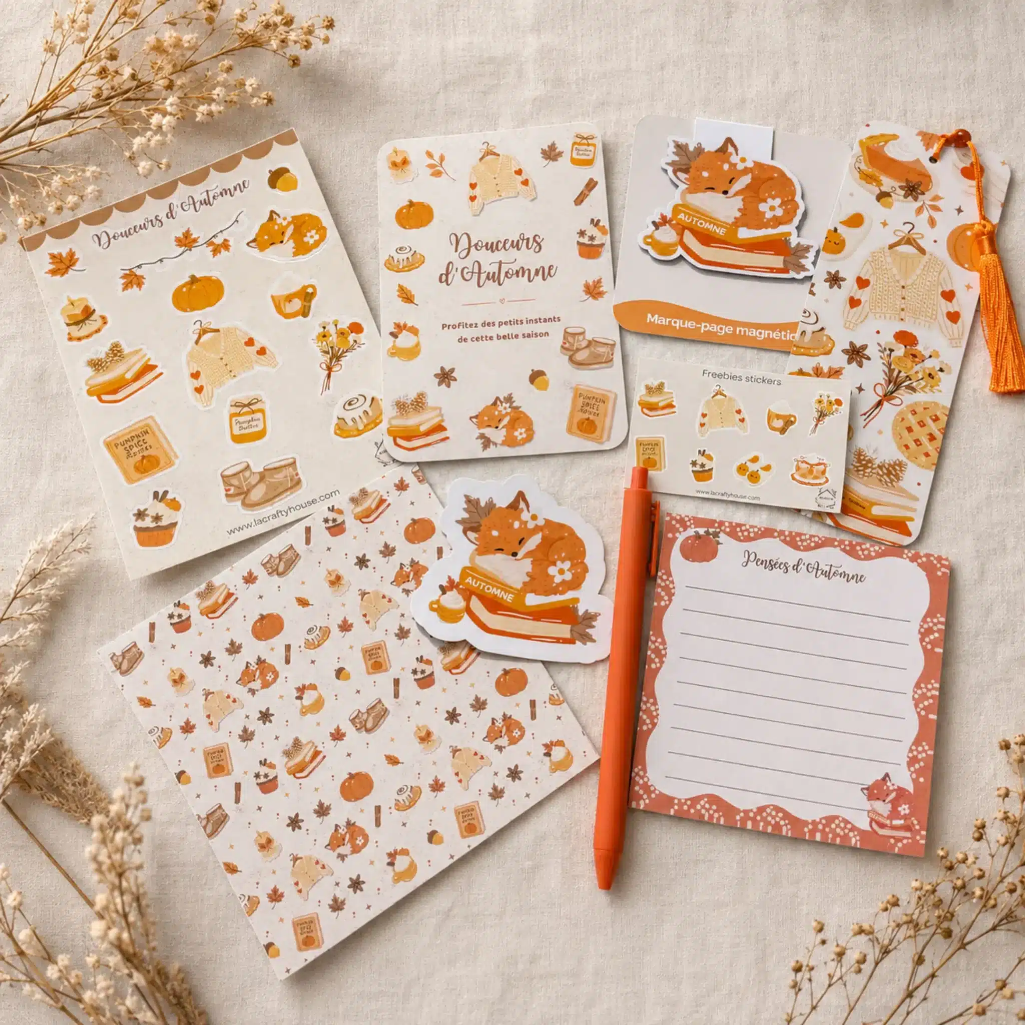 Contenu de la box papeterie Douceurs d’Automne à plat : stickers renard, print A5, papier de scrapbooking, marque-pages, bloc-notes et stylo orange