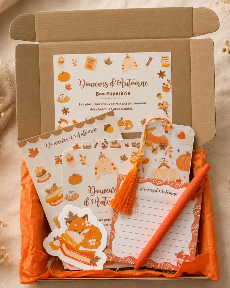 Box papeterie Douceurs d’Automne ouverte : carte, planche de stickers, marque-page à pompon orange, sticker renard, bloc-notes et stylo sur papier de soie orange