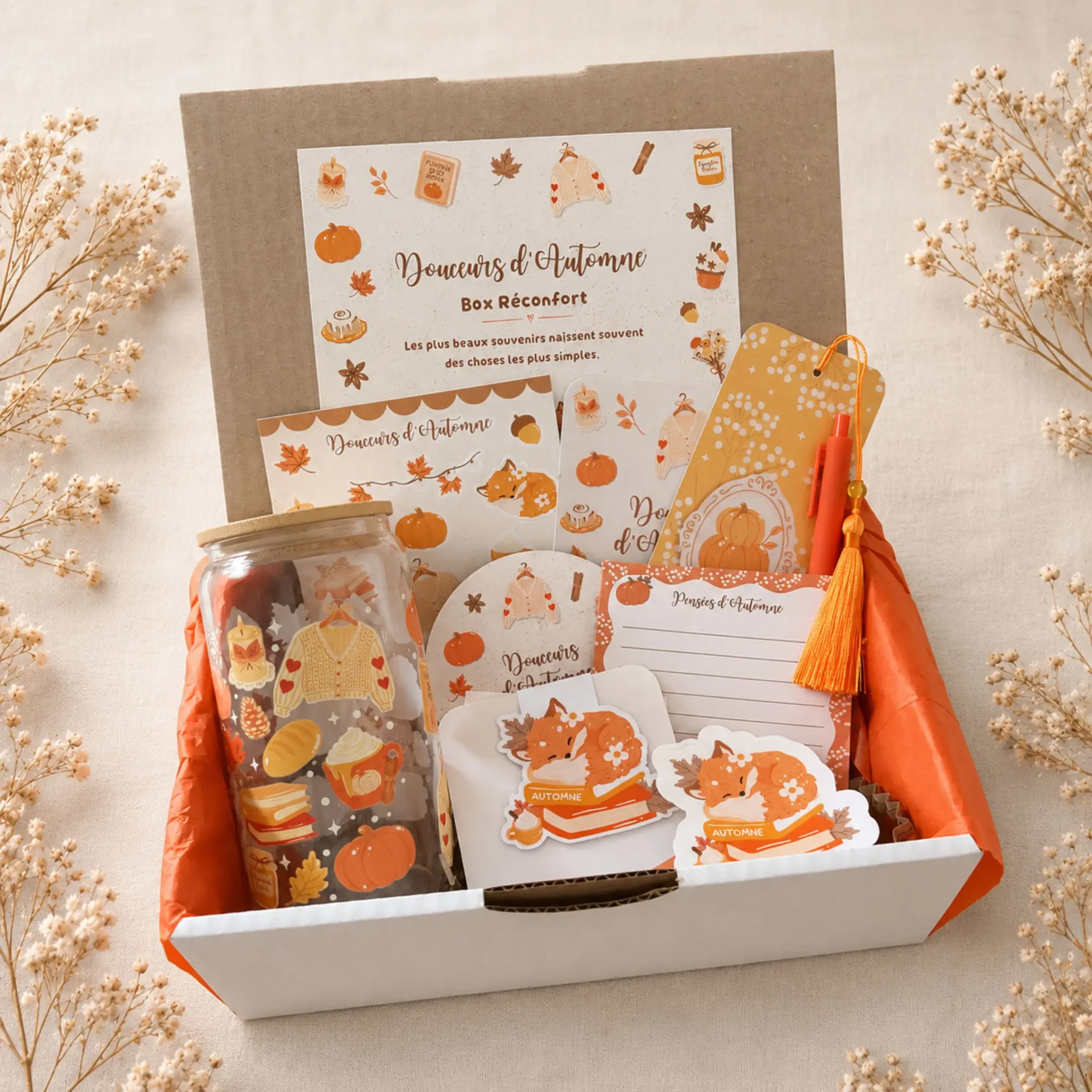 Box Réconfort Douceurs d’Automne ouverte : gobelet en verre à couvercle bambou, planche de stickers renard, marque-page à pompon orange, sous-verre et bloc-notes